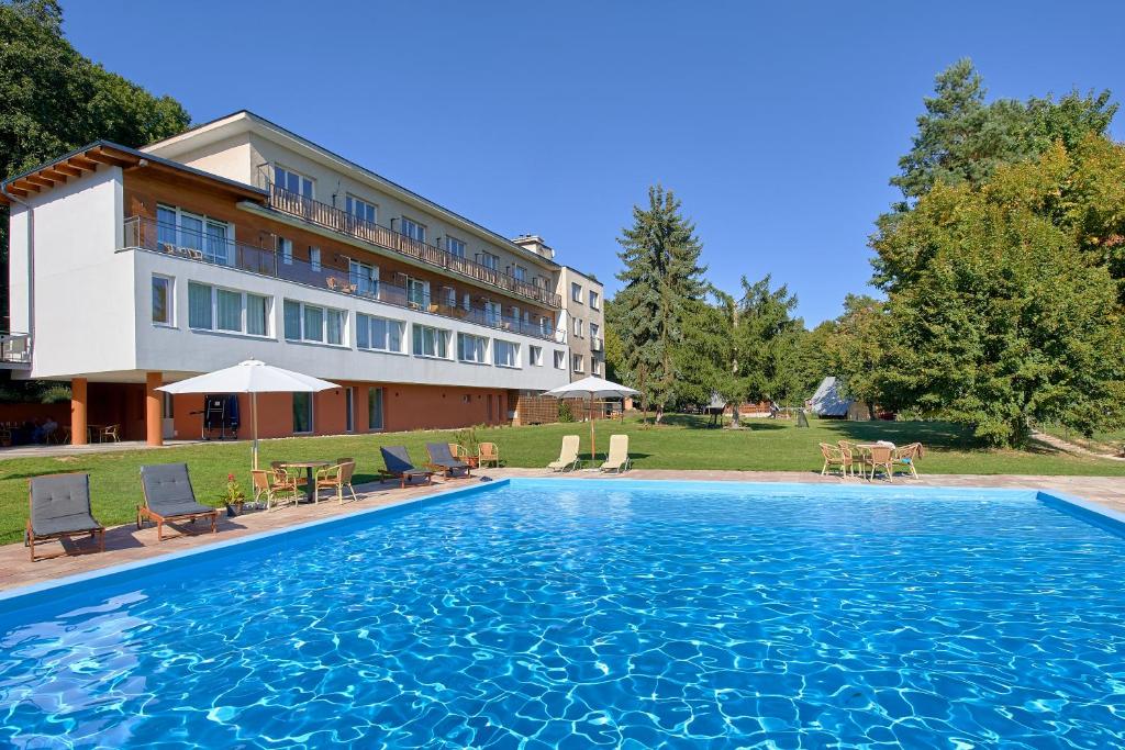 a large swimming pool in front of a building at Hotel Kochau in Kováčová