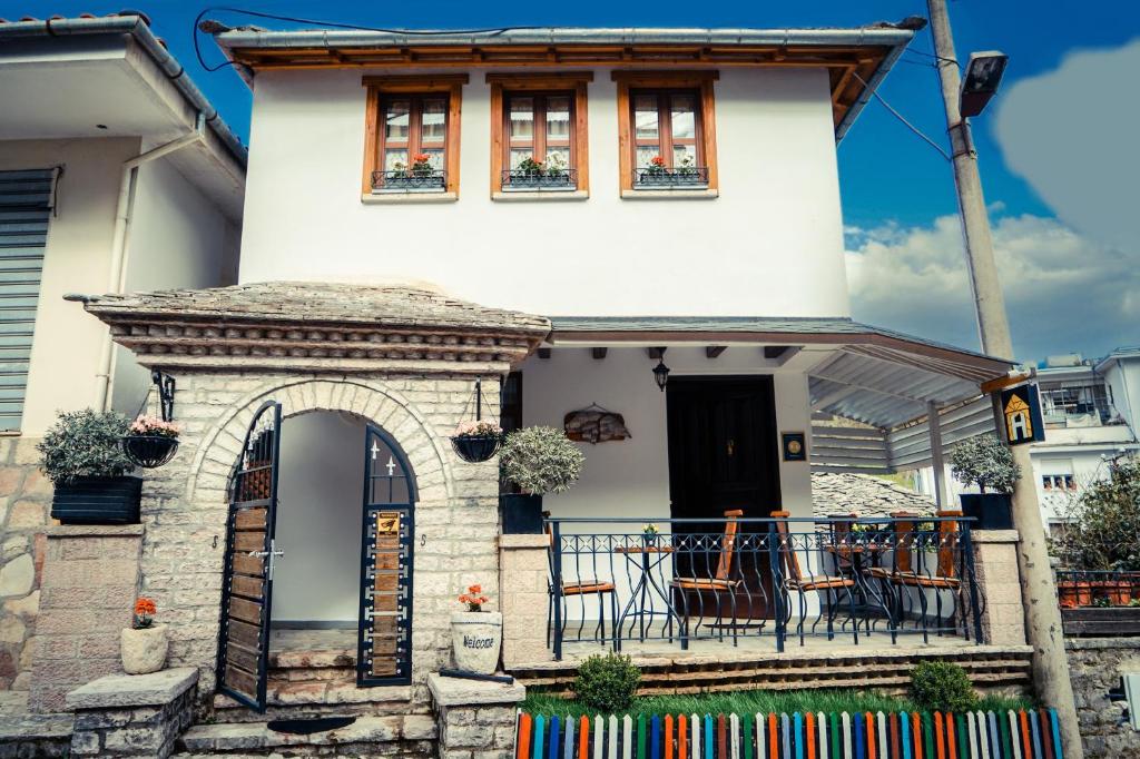 a house with a balcony with chairs on it at Hotel Domino in Gjirokastër