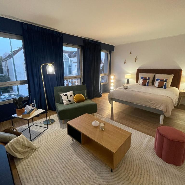 une chambre avec un lit et un salon dans l'établissement Appartement Entre Paris et Disney, à Ozoir-la-Ferrière
