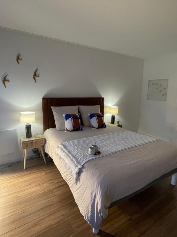 a bedroom with a large bed with birds on the wall at Appartement Entre Paris et Disney in Ozoir-la-Ferrière