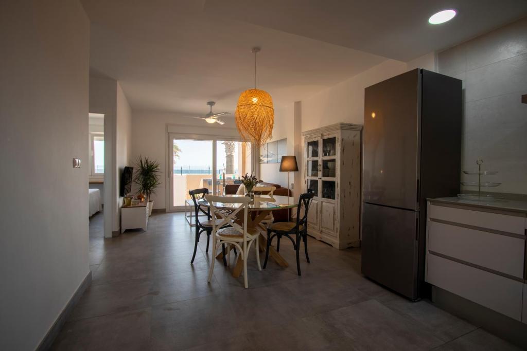 eine Küche und ein Esszimmer mit einem Tisch und Stühlen in der Unterkunft Apartamento en primera línea de playa in Tarifa