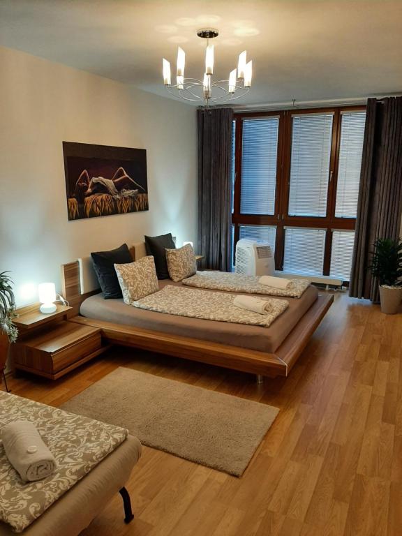 a bedroom with a large bed and a large window at Nobless Apartment Brno in Brno