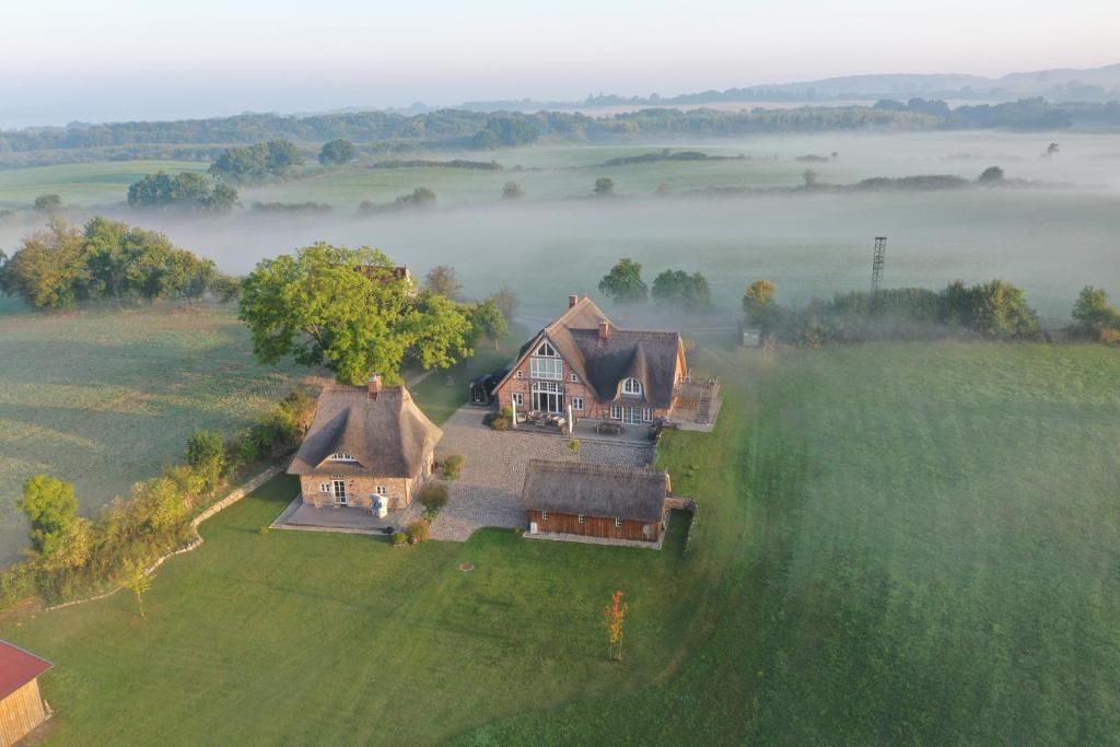 uma vista aérea de uma casa sobre um campo no nevoeiro em Reethaus Hoheleuchte em Römnitz