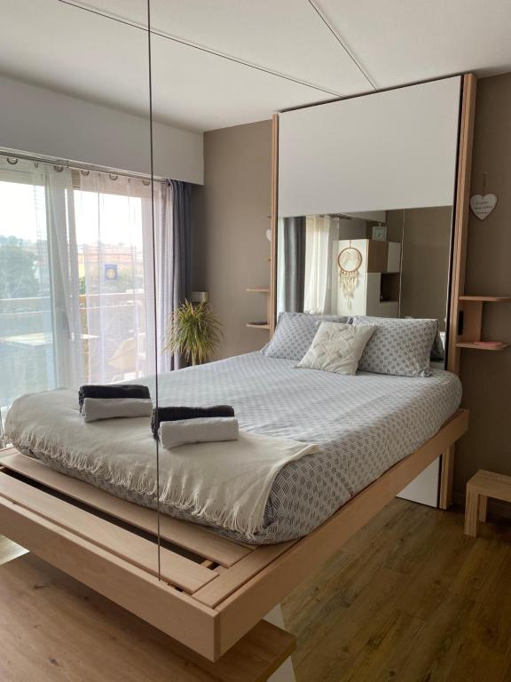 sypialnia z dużym łóżkiem ze szklaną ścianą w obiekcie Le Petit mouchoir et son garage w miejscowości Sainte-Maxime