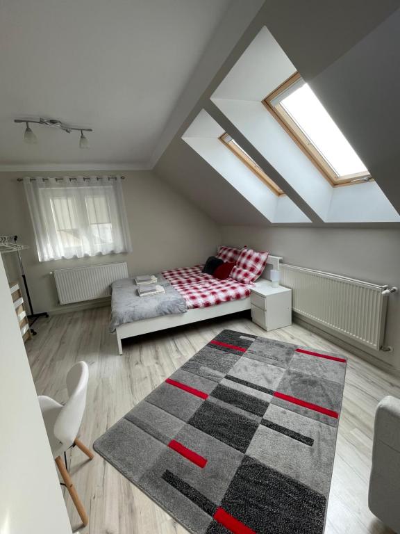 a attic room with a bed and a rug at Mieszkanie Giżycko in Giżycko