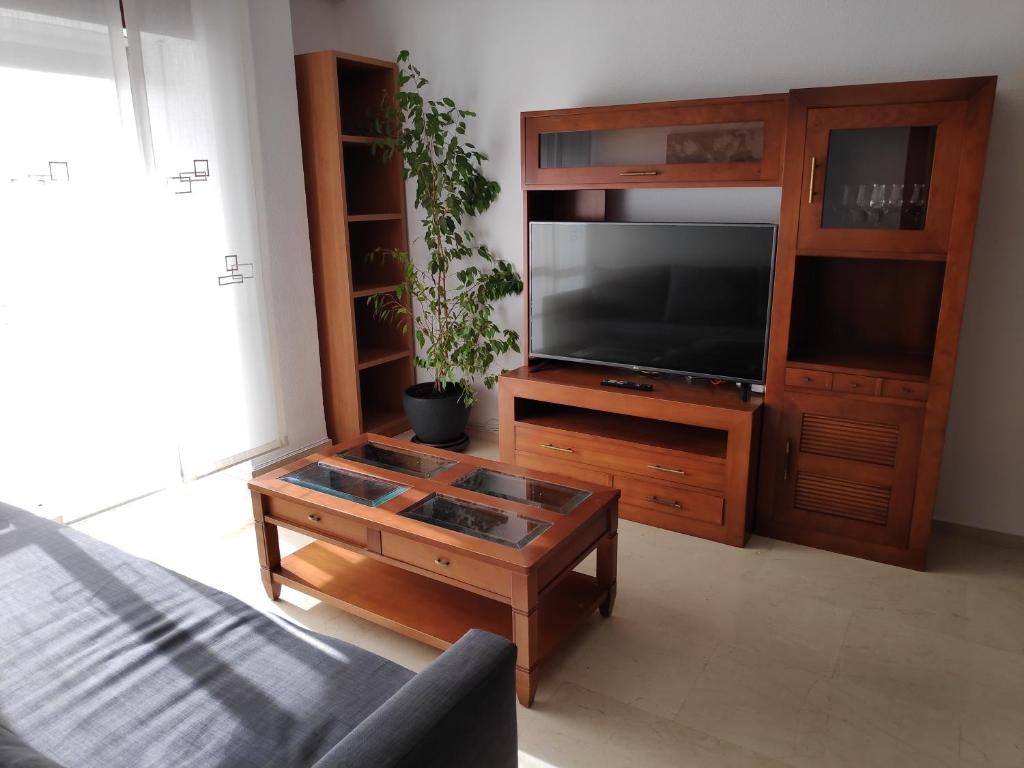 uma sala de estar com uma televisão e uma mesa de centro em Victoria Home Córdoba em Córdoba