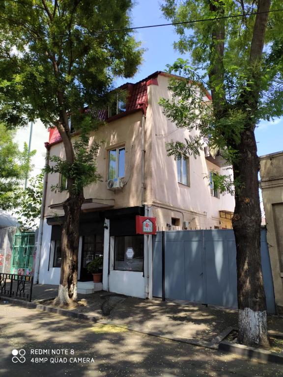 ein Gebäude mit zwei Bäumen davor in der Unterkunft Rose House in Tbilisi City
