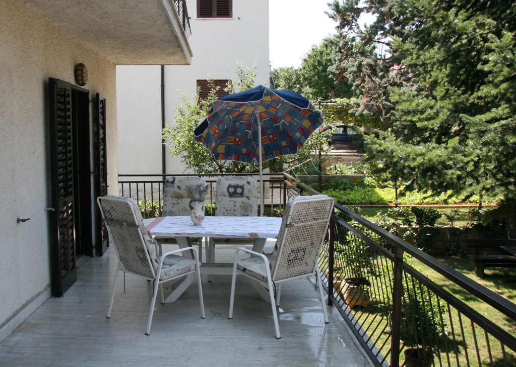 a table and chairs on a balcony with an umbrella at Pineta House Vidos in Poreč