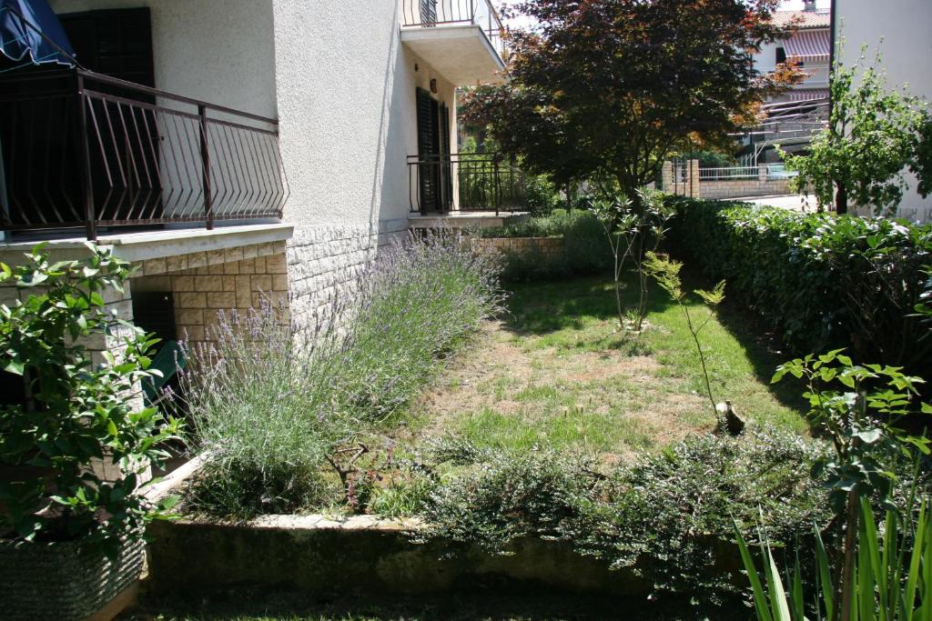 a garden in front of a building with a bird in the yard at Pineta House Vidos in Poreč