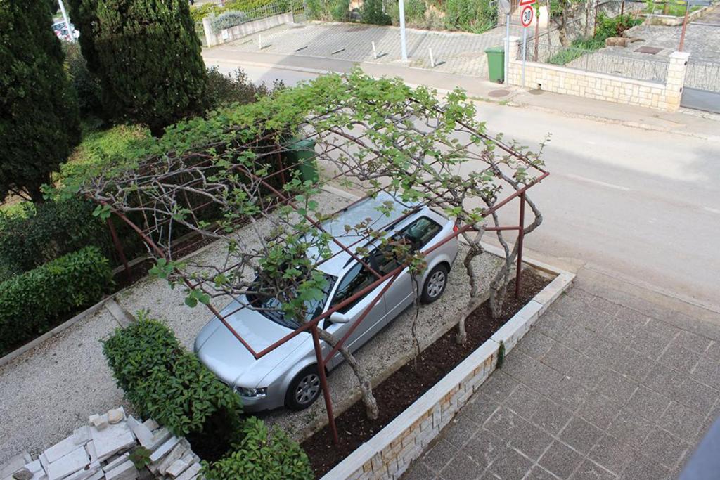a small silver car parked under a tree at Pineta House Vidos in Poreč