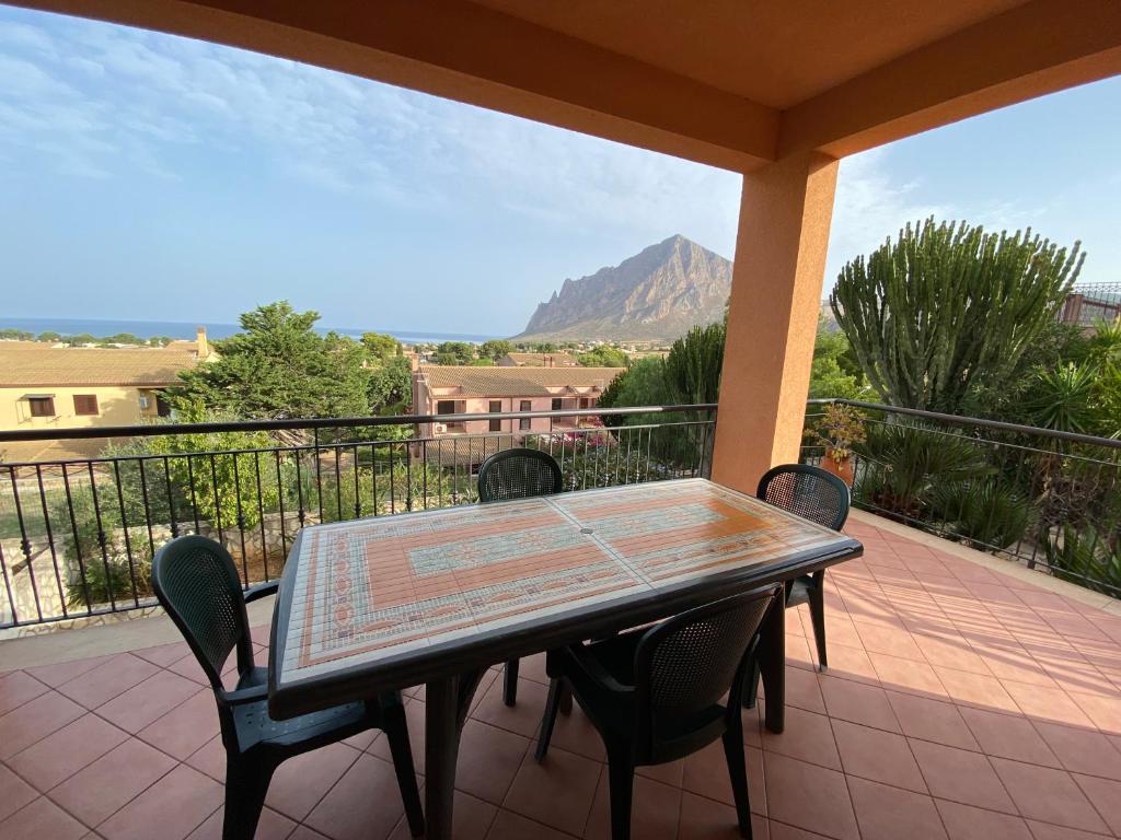 a table and chairs on a balcony with a view of a mountain at Villa dei Tramonti in Custonaci