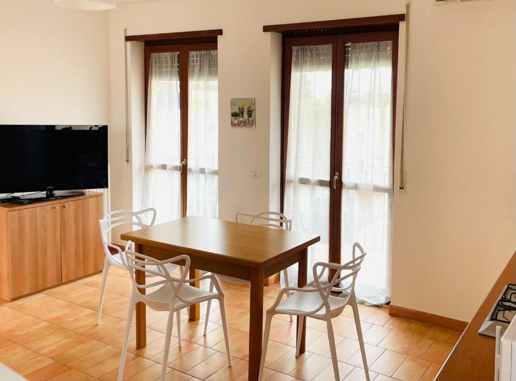 Appartamento Giallo في بسكيرا ديل غاردا: غرفة طعام مع طاولة وكراسي خشبية