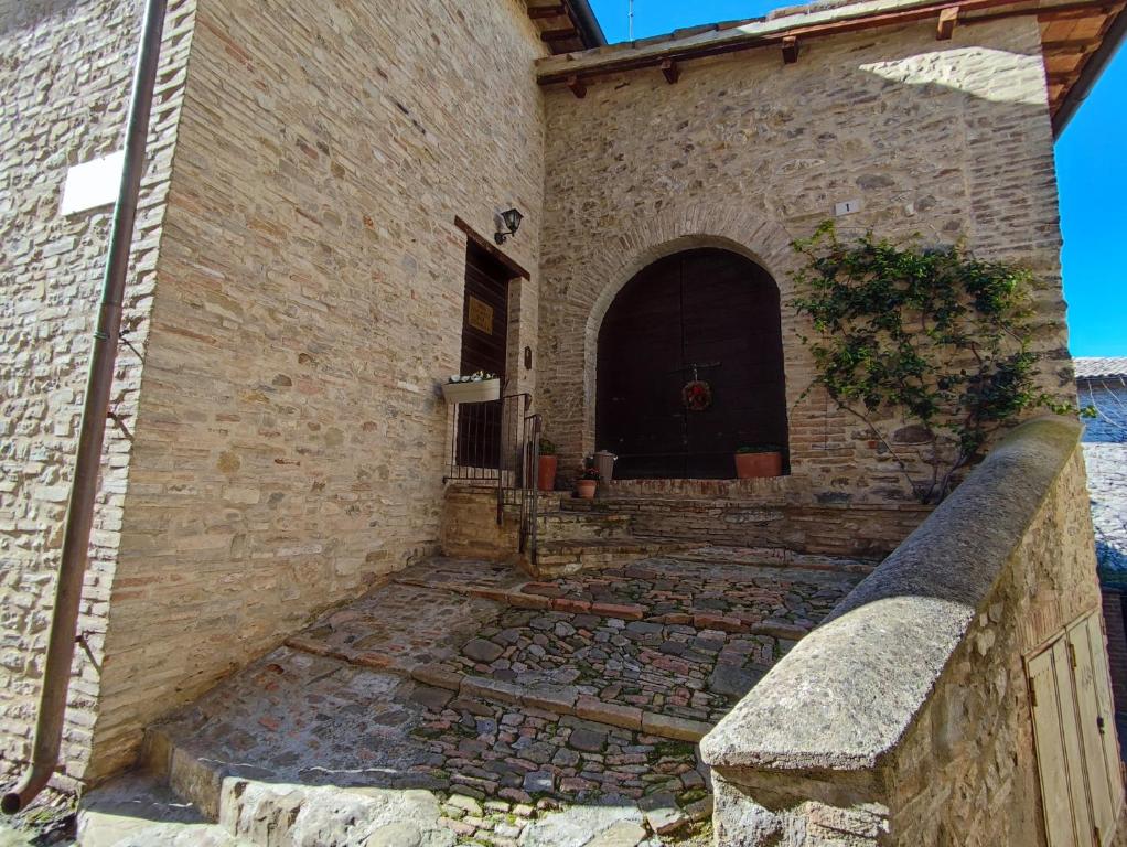a brick building with a door and a stone wall at Casa Vacanze del Console in Bevagna