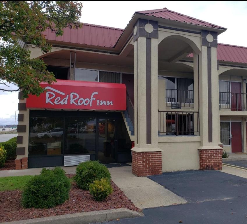 a red brick building with a red umbrella at Red Roof Inn Portsmouth - Wheelersburg in Wheelersburg