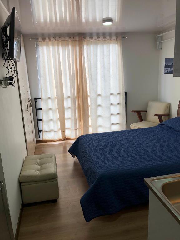 1 dormitorio con 1 cama azul y 1 silla en Apt calle 75 302, en Bogotá