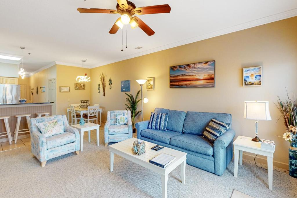 a living room with a blue couch and chairs at Ohana KDH122 in Kill Devil Hills