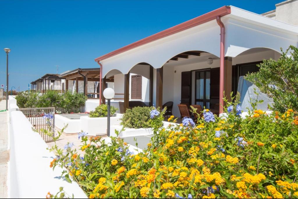 a house with flowers in front of it at Villa Maldive del Salento in Marina di Pescoluse