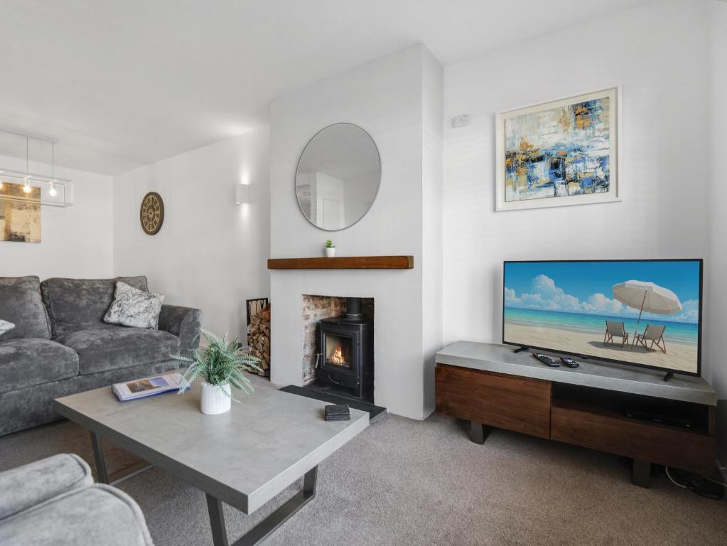 a living room with a couch and a television at Sid Valley View - Scenic end of terrace town house in Sidmouth