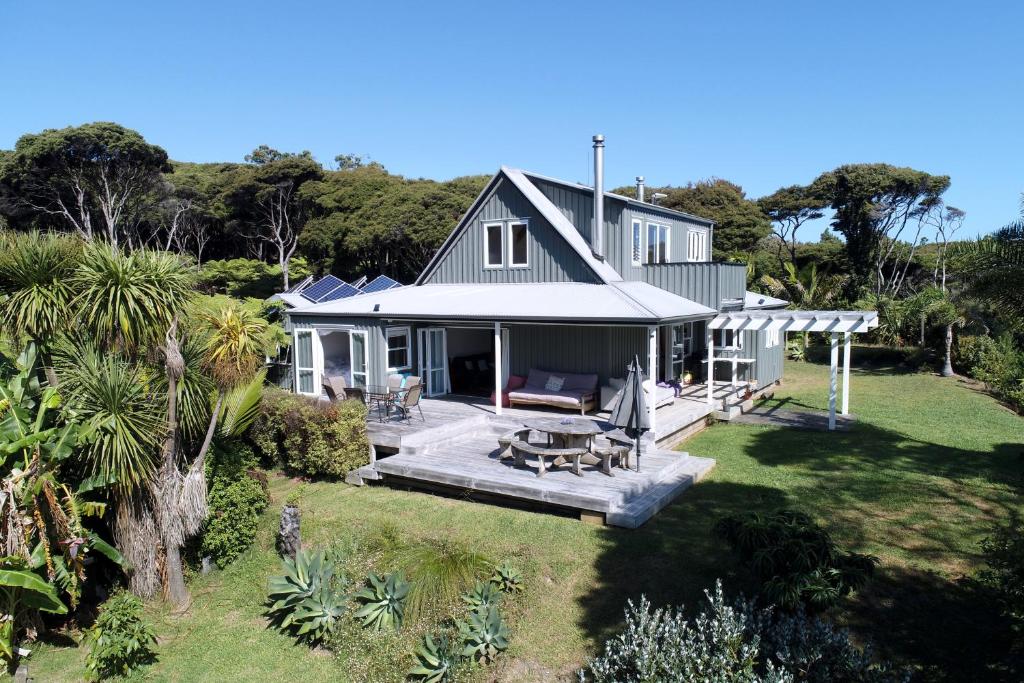 Elle offre une vue aérienne sur une maison dotée d'une terrasse. dans l'établissement Frosty's Retreat - Great Barrier Island Home, à Tryphena