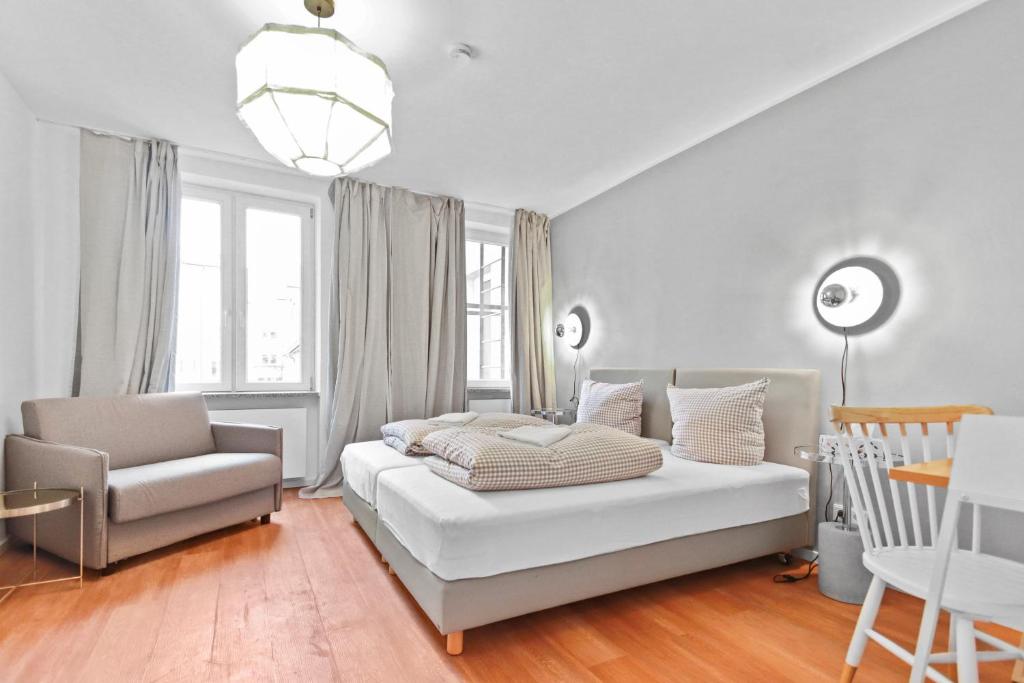 - une chambre blanche avec un lit et une chaise dans l'établissement Flatista Homes - Central Station - 3BR, à Munich