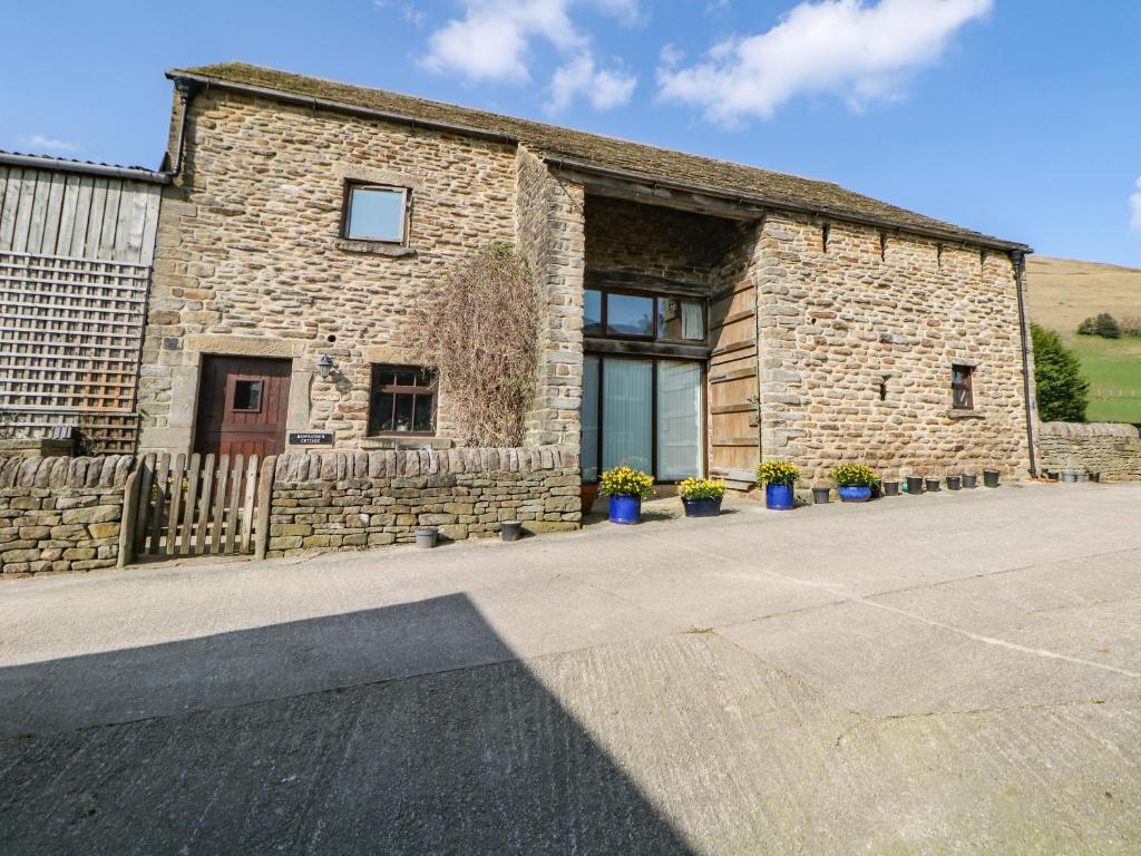 a stone building with potted plants in front of it at Midfeather Cottage in Edale