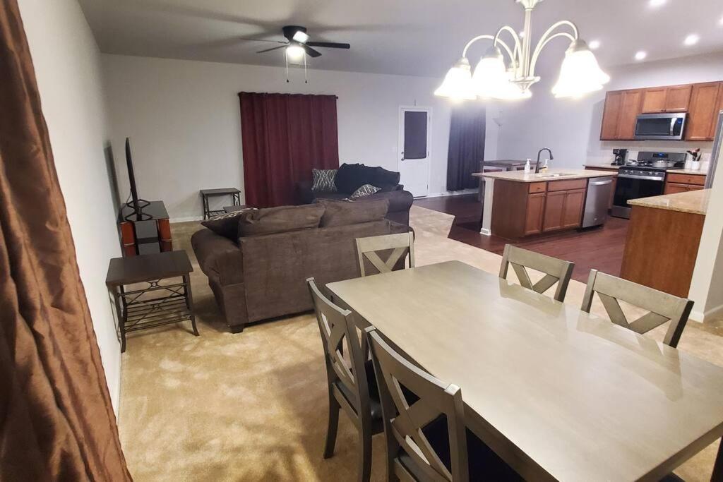 ein Wohnzimmer und eine Küche mit einem Tisch und einem Sofa in der Unterkunft New 3 Bedroom Home w/ tons of amenities & parking. in McDonough