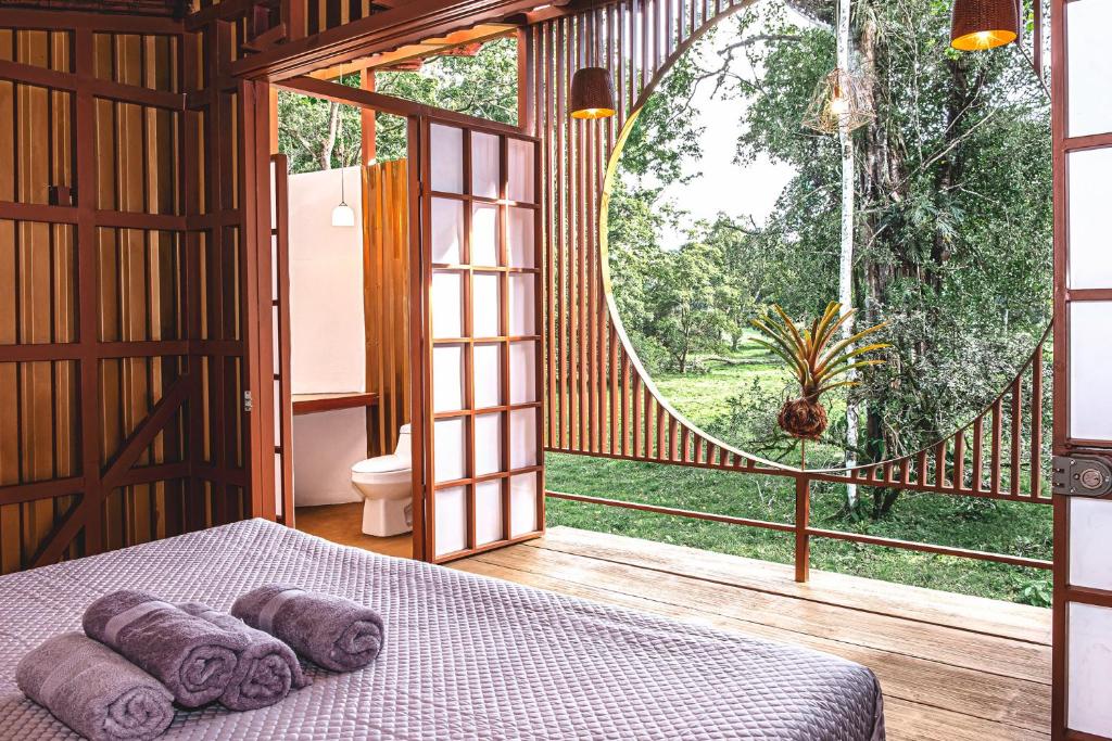1 dormitorio con cama y ventana grande en The Mimosas - Beautiful Unique Container Homes with Pool en Hone Creek