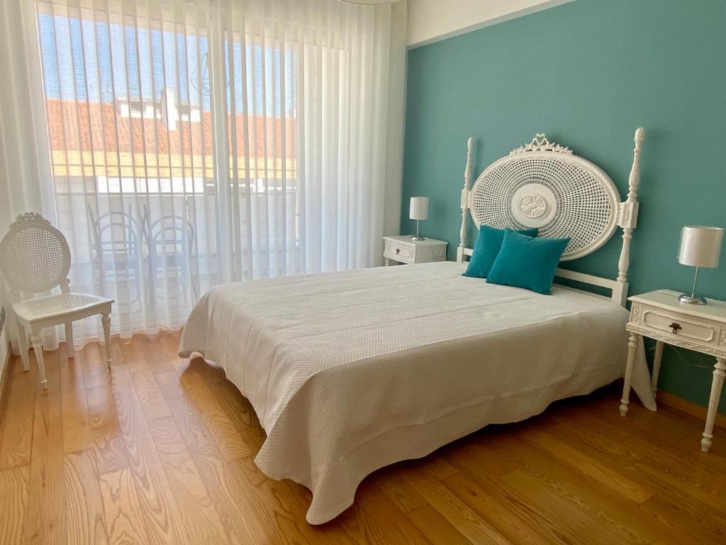 um quarto com uma cama grande e uma janela grande em Apartamento O Albuquerque - Centro Cidade Alcobaça em Alcobaça
