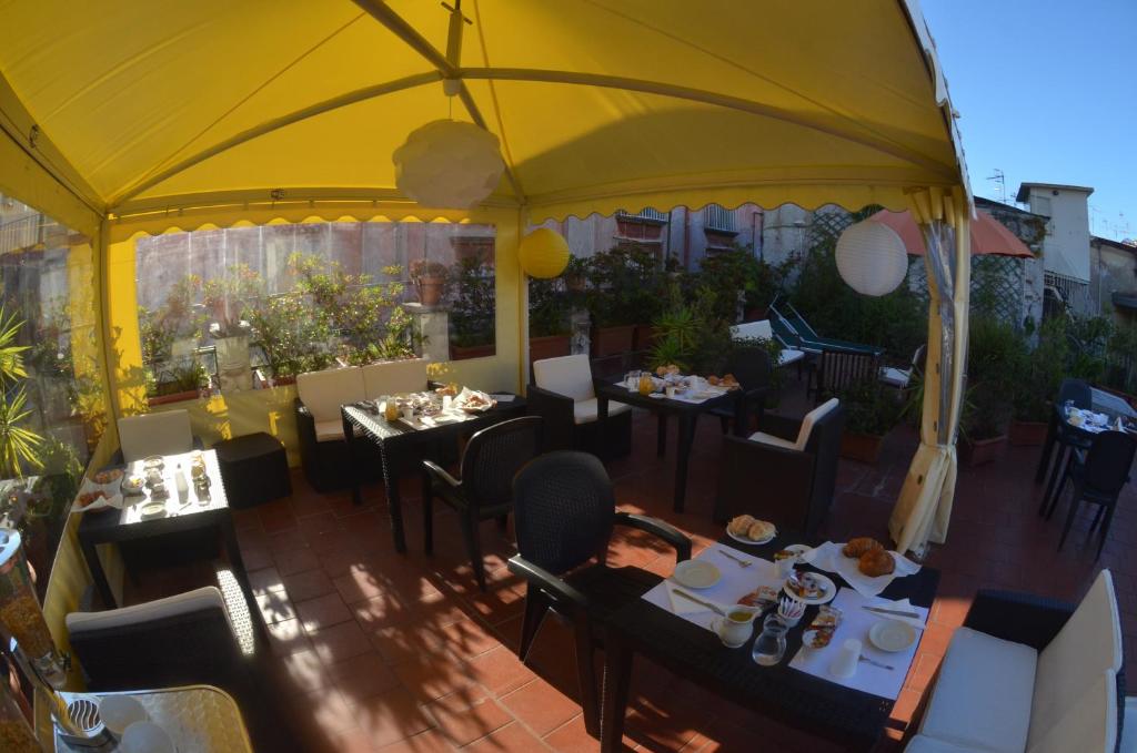 ナポリにあるBed and Breakfast I Vicoletti Di Napoliのテーブルと椅子、黄色い傘が備わるレストラン