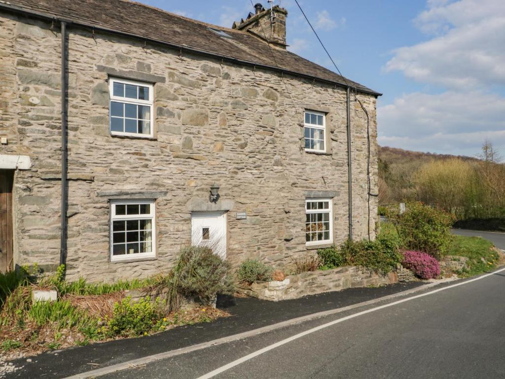 an old stone house on the side of a road at Duddon Cottage in Broughton in Furness