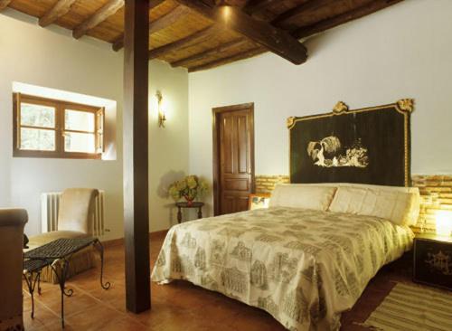 a bedroom with a bed and a chair in it at El Jardin del Conde in Puerto de Béjar