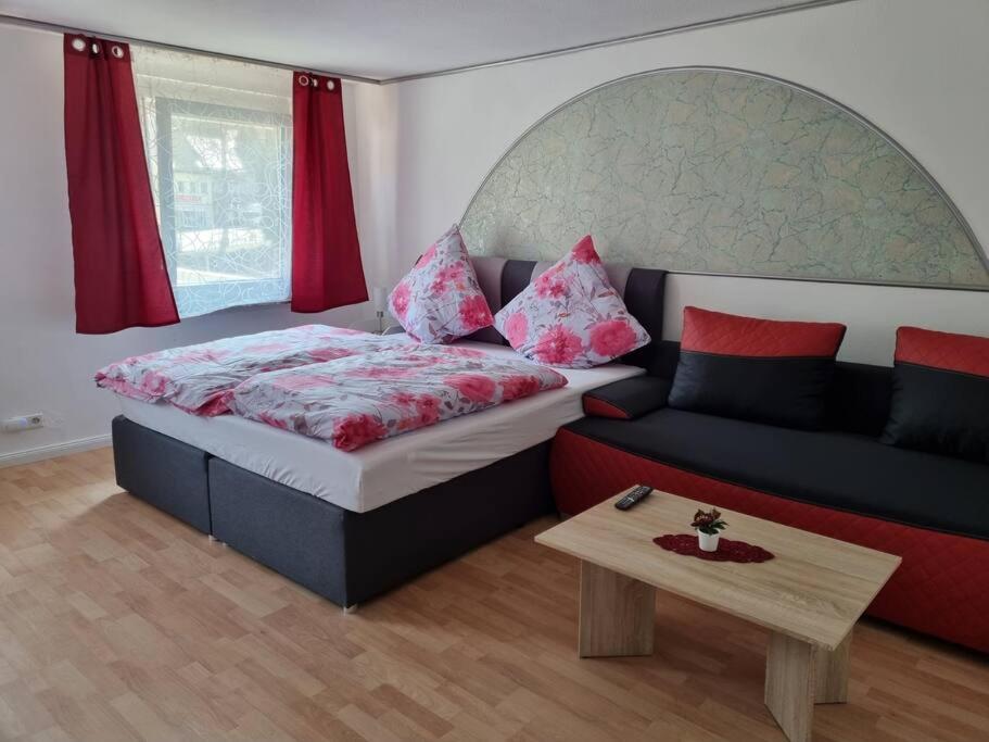 a bedroom with a bed and a couch and a table at KM2 Apartment in Triberg