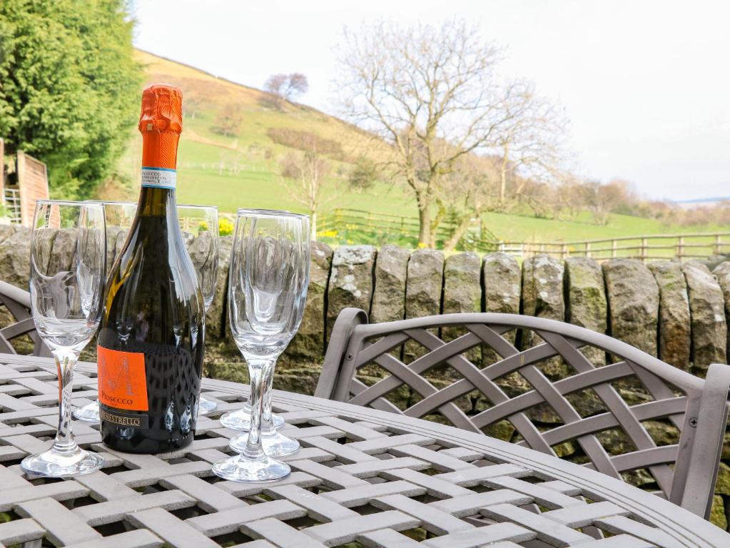 eine Flasche Wein auf einem Tisch mit Weingläsern in der Unterkunft Meadow View in Edale