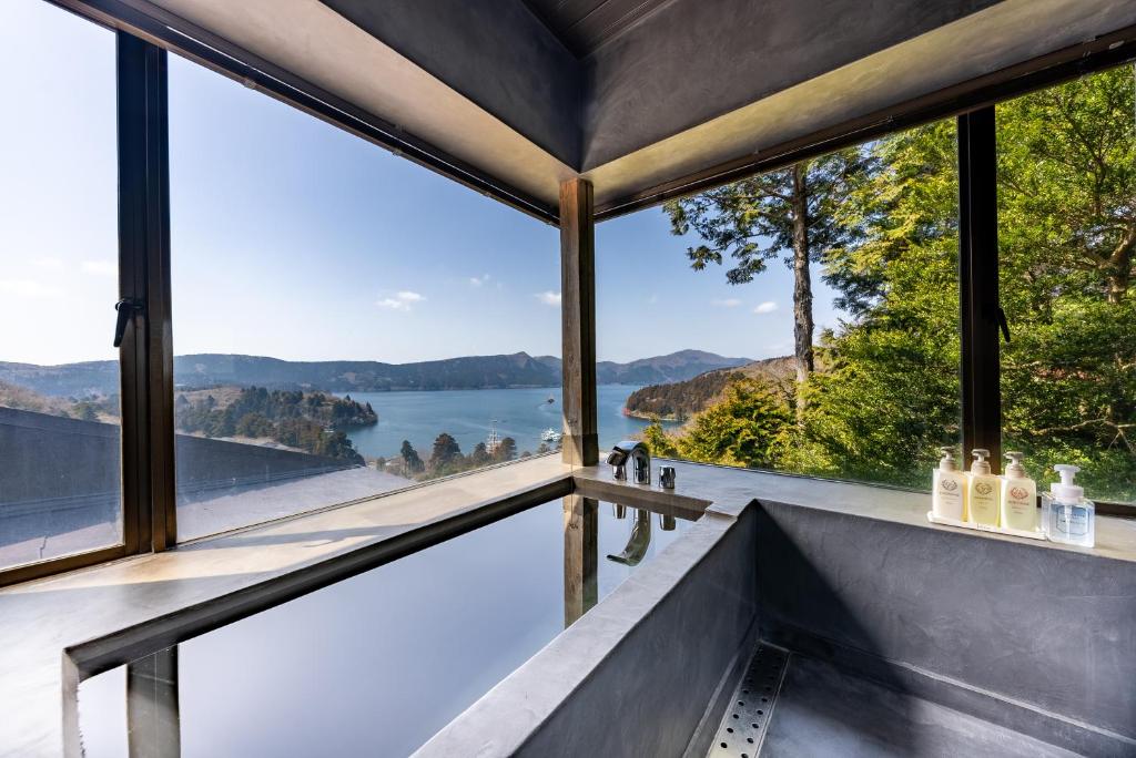 uma casa de vidro com vista para a água em VILLA HAKONE湖空 em Hakone