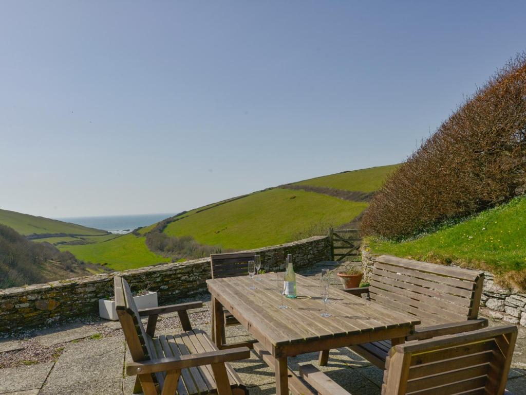 a wooden table and chairs with a view of the ocean at Ayrmer House in Bigbury