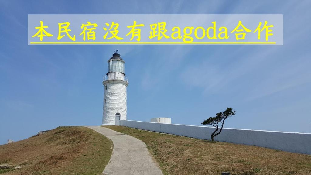 a lighthouse on top of a hill with a sign at Dapu Inn in Juguang