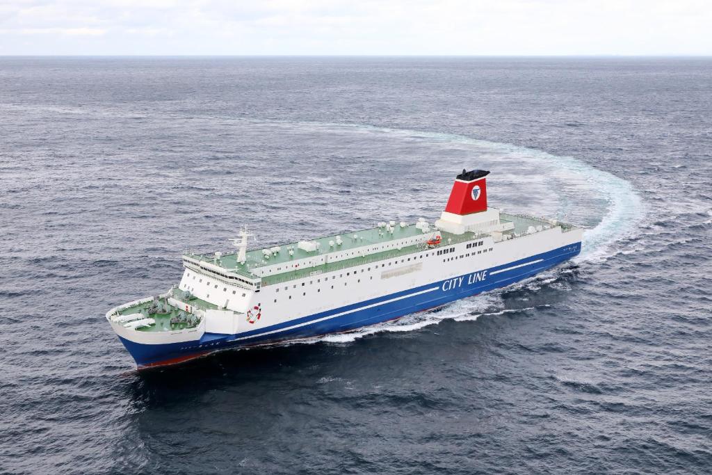 un gran barco con un faro rojo en el océano en Meimon Taiyo Ferry 2nd sailing from Osaka to Kitakyushu en Osaka