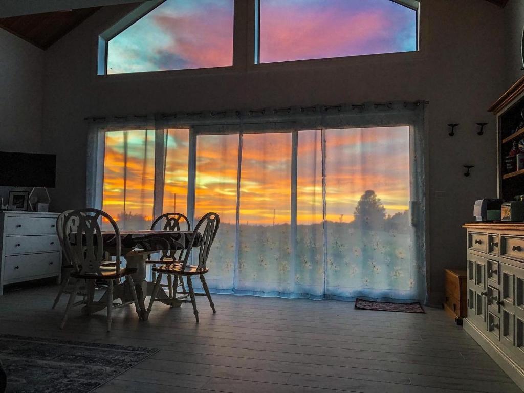 a dining room with a table and chairs in front of a window at White Caps Kaikoura Farmstay in Kaikoura