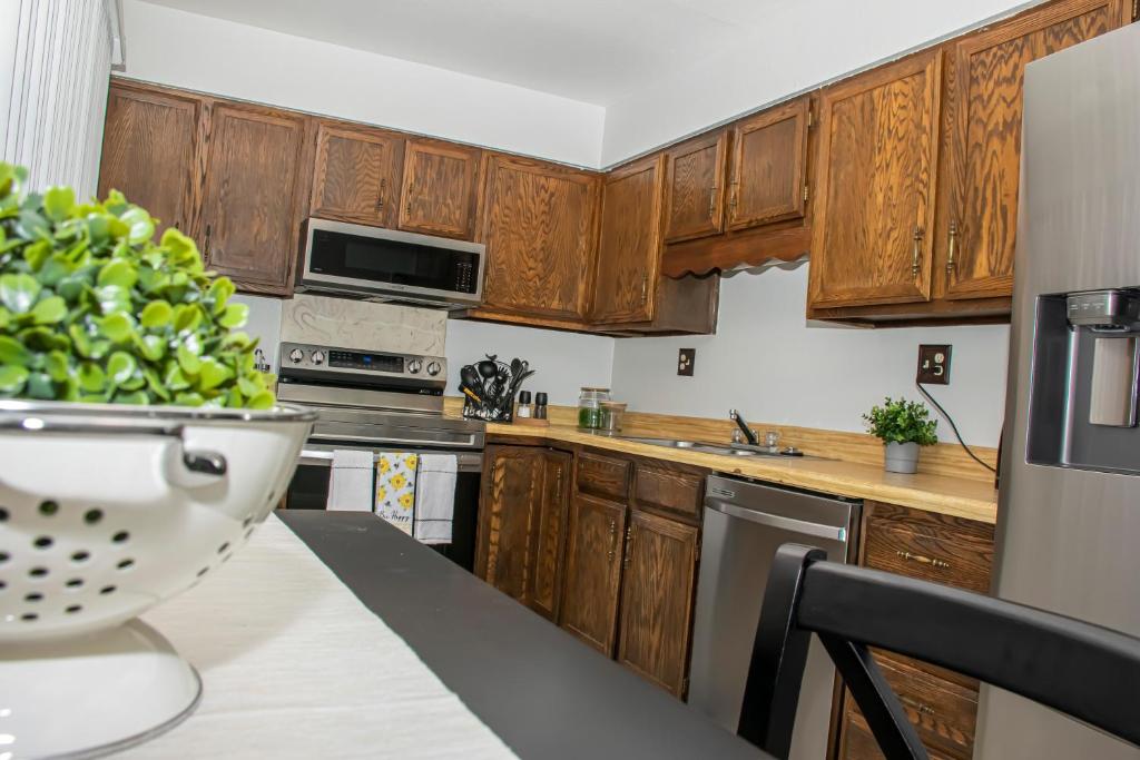 コロラドスプリングスにあるLovely 2 bedroom! Close to All in a 4Plexのキッチン(木製のキャビネット、テーブルの上に食べ物を入れた器付)