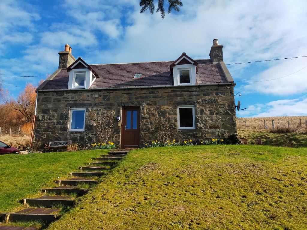 an old stone house on a hill with stairs at Ornum in Skerray