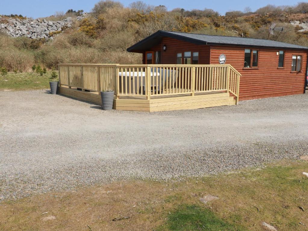 uma casa com um grande deque de madeira em frente em Costentyn, Tor Down Quarry em Bodmin