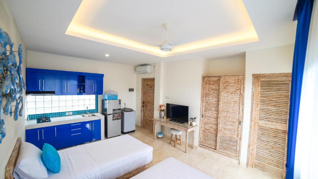 eine Küche mit blauen Schränken und einer weißen Couch in der Unterkunft Ocean Star Apartment Sanur in Sanur