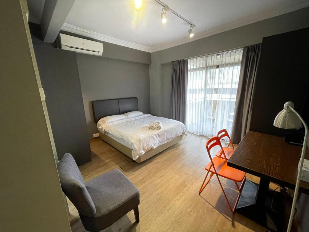 una camera con letto, sedia e scrivania di Greatwood Residence at Devonshire a Singapore