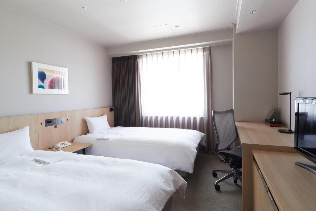 Postel nebo postele na pokoji v ubytování Rhino Hotel Kyoto
