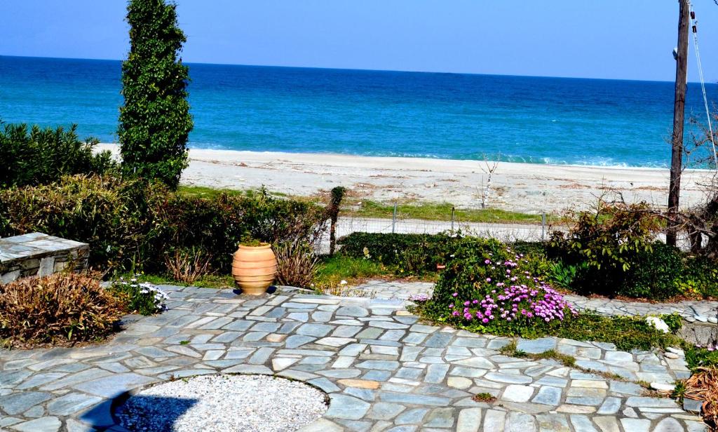 a stone walkway next to a beach with the ocean at Electra Beach House in Chorefto