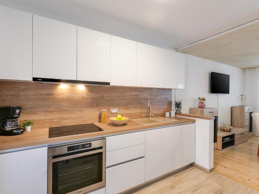 a kitchen with white cabinets and a sink at Apartments Nada in Poreč