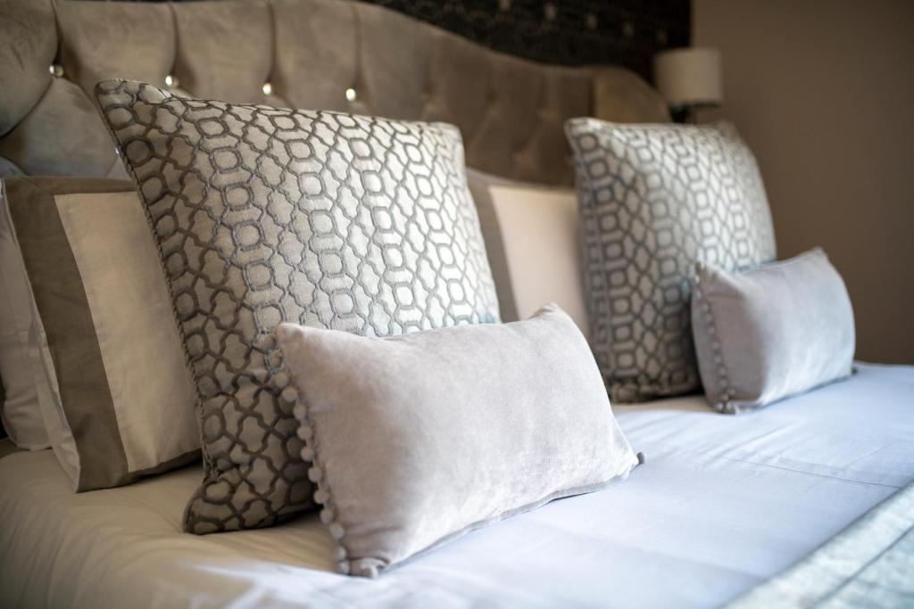 Una cama con almohadas y sábanas blancas. en Dryburgh Town House, en Inverness