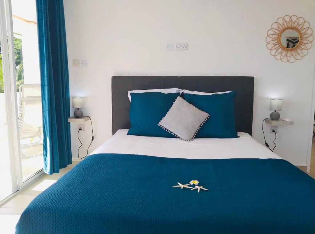 1 dormitorio con 1 cama con sábanas azules y blancas en Cap Confort en Au Cap