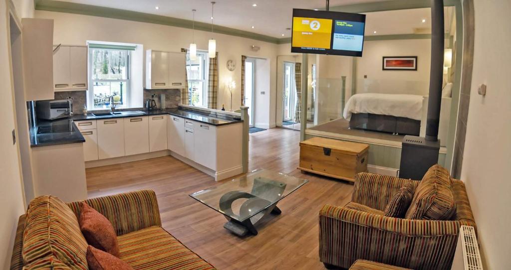 een woonkamer met 2 banken en een keuken bij Owls Nest in Edinbain