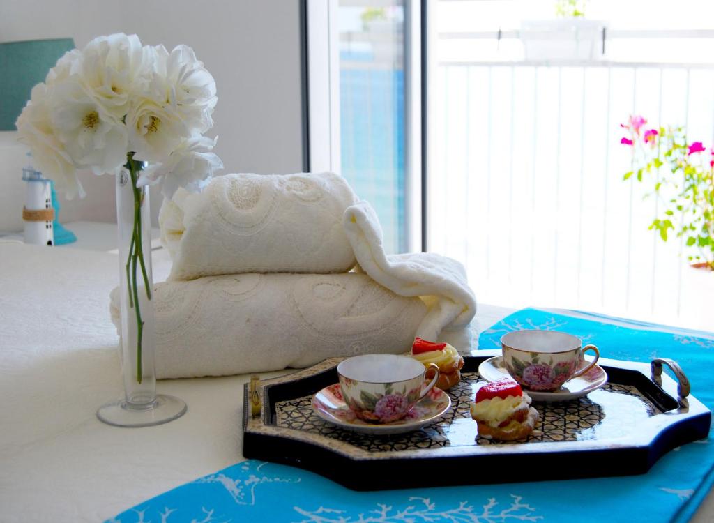 un vassoio di cupcake e due tazze su un tavolo di B&B Capo Rizzuto fronte Mare a Capo Rizzuto